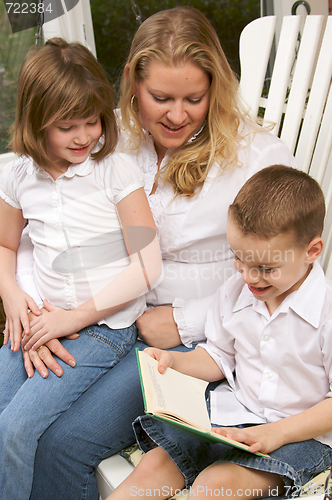 Image of Young Boy Reads to His Mother and Sister