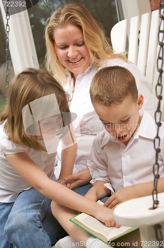 Image of Young Boy Reads to His Mother and Sister