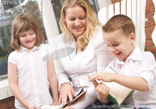 Image of Young Boy Reads to His Mother and Sister