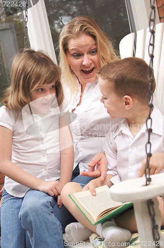 Image of Young Boy Reads to His Mother and Sister