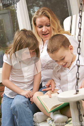 Image of Young Boy Reads to His Mother and Sister