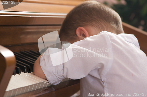 Image of Young Boy with Head on the Piano