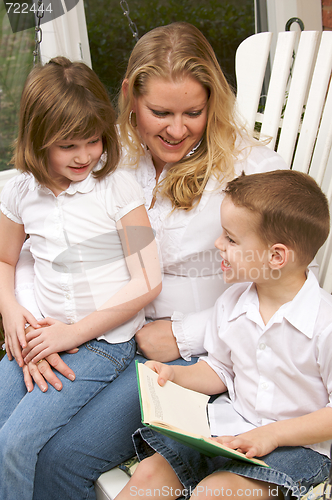 Image of Young Boy Reads to His Mother and Sister