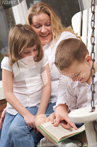 Image of Young Boy Reads to His Mother and Sister