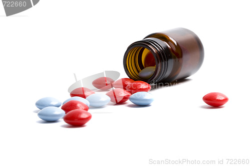 Image of glass bottle with red and blue pills 