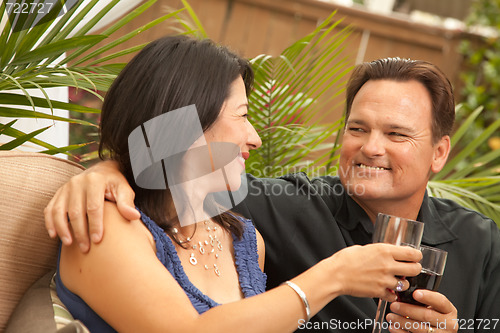 Image of Attractive Hispanic and Caucasian Couple Drinking Wine