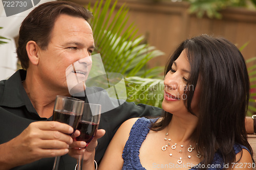 Image of Attractive Hispanic and Caucasian Couple Drinking Wine