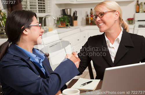 Image of Businesswomen Shaking Hands Working on the Laptop