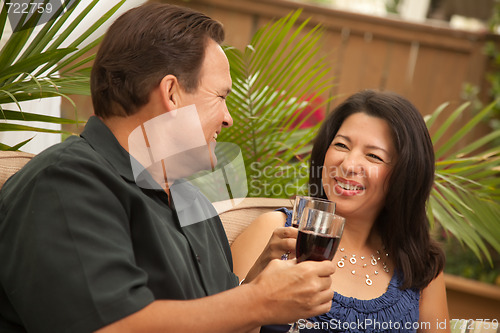 Image of Attractive Hispanic and Caucasian Couple Drinking Wine