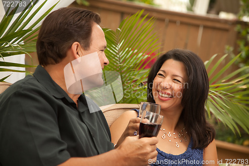 Image of Attractive Hispanic and Caucasian Couple Drinking Wine