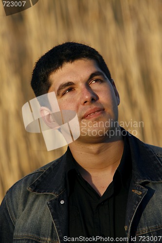 Image of Young man looking aside with a thoughtful look on his face