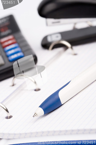 Image of  business organizer, pen, calculator and stapler