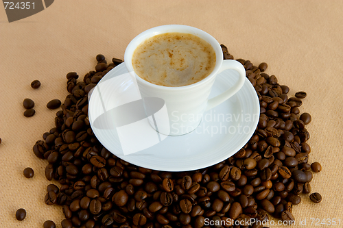 Image of Cup with coffee, costing on coffee grain