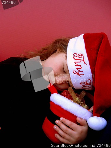 Image of Sleeping little girl wearing santa hat