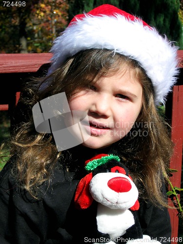 Image of Pretty little girl outside wearing santa hat