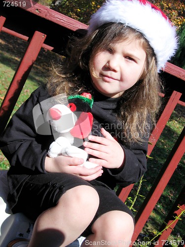 Image of Cute little girl in santa hat outside