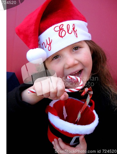 Image of Little girl in Elf Hat eating candy canes