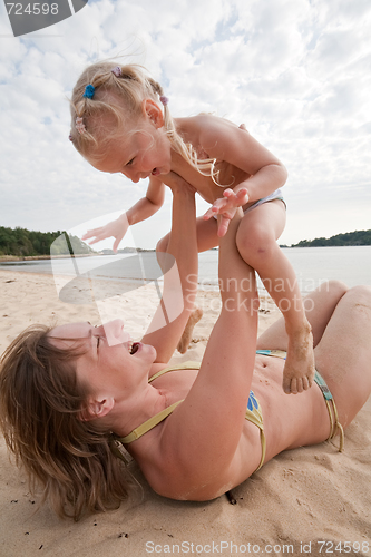 Image of Mum with daughter play on beach