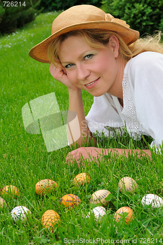 Image of Young woman and easter eggs on the grass - Easter time