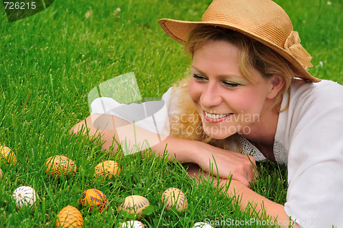 Image of Young woman and easter eggs on the grass - Easter time