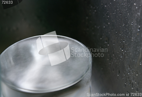 Image of A glass of water within a steel metal water splashed environment