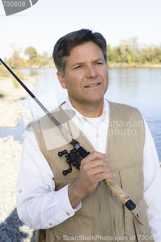 Image of Man Standing With Fishing Pole