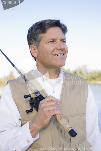 Image of Man Standing With Fishing Pole