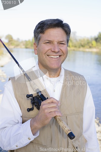 Image of Man Standing With a Fishing Pole