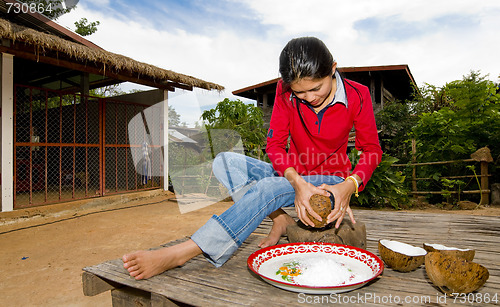 Image of thai girl removing coconut meat from shell