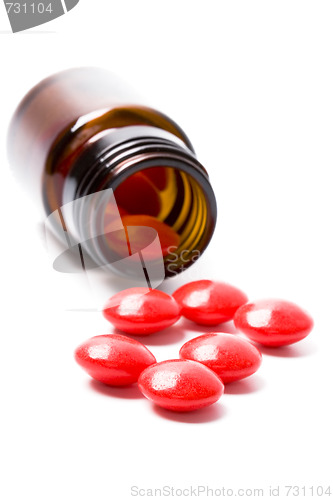 Image of glass bottle with red pills