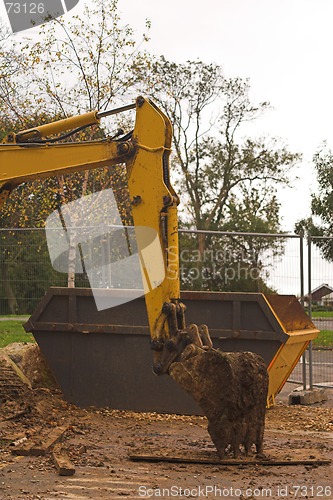 Image of Digger arm with dumpster behind