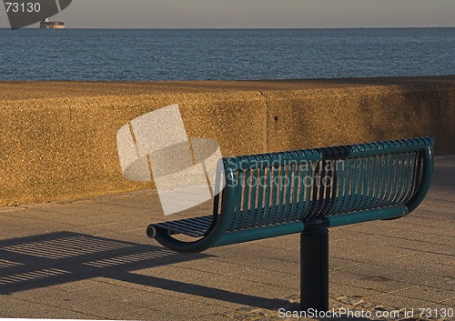 Image of Green metal seat overlooking sea