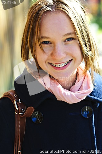 Image of Happy teenage girl in coat