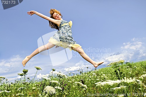 Image of Young girl jumping in meadow