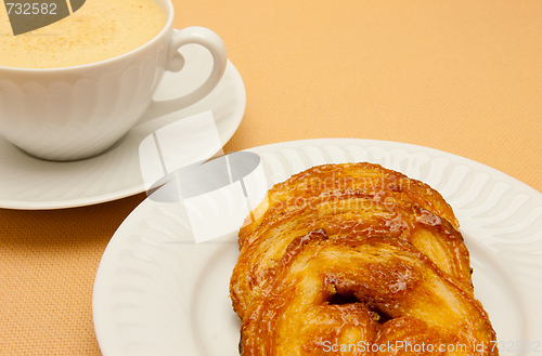 Image of Closeup of coffee with milk in white cup and a palmier pastry