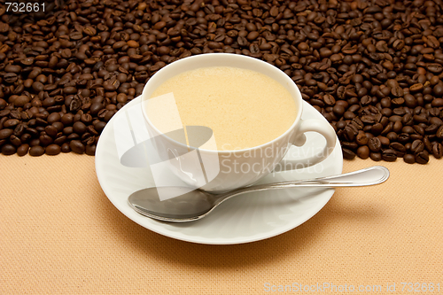 Image of White cup of coffee and coffee beans