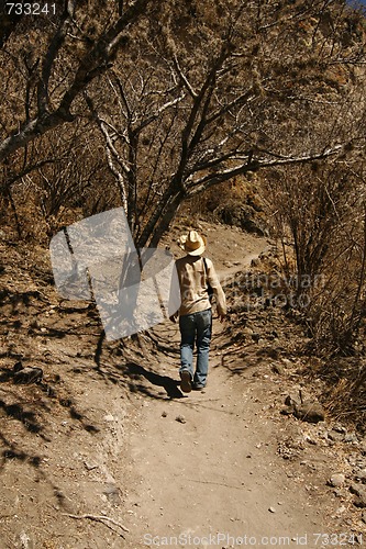 Image of A man with a hat walking up the hillside in Mexican desert