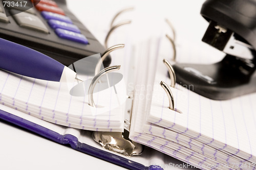 Image of business organizer, pen, calculator and stapler