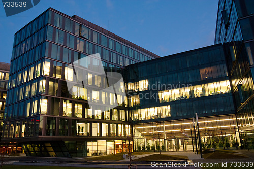 Image of complex of office buildings from glass in the evening with the windows