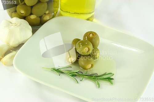 Image of Stuffed pickled Olives in dish with olive oil. 