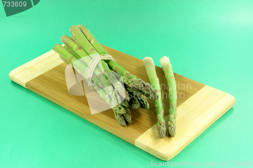 Image of Pile of asparagus over green background. 