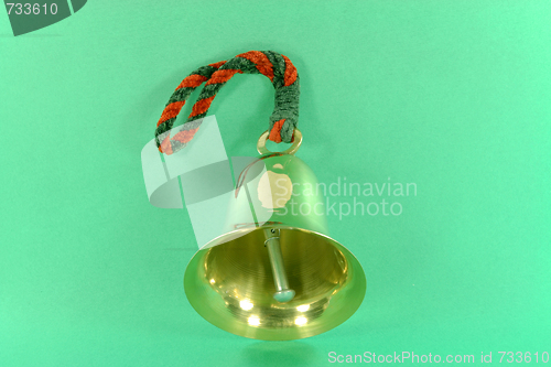 Image of Hand bell over green background. 