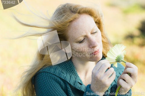 Image of Woman Looking at Flower
