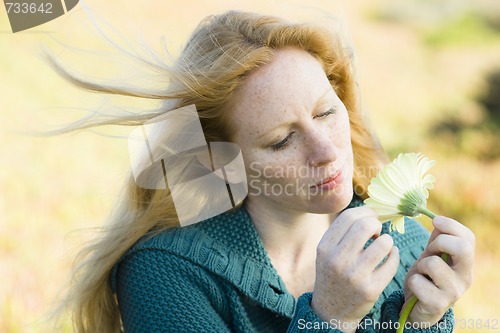 Image of Woman Looking at Flower