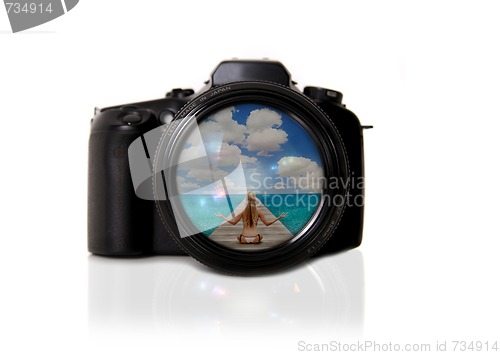 Image of Digital SLR Isolated With Reflected Image of the Beach in the Le