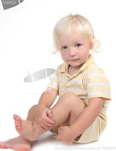 Image of Innocent Child Sitting and Holding His Leg