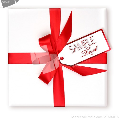 Image of Pretty Wrapped Holiday Gift With Red Ribbon and Gift Tag