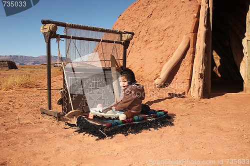 Image of Navajo Child Sitting Next to Traditional Rug Making Tools