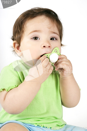 Image of Baby putting a dummy into mouth