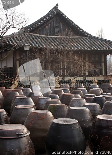 Image of Kimchi pots in front of a traditional Korean home